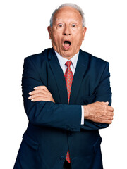 Poster - Senior business man with grey hair with arms crossed gesture afraid and shocked with surprise and amazed expression, fear and excited face.