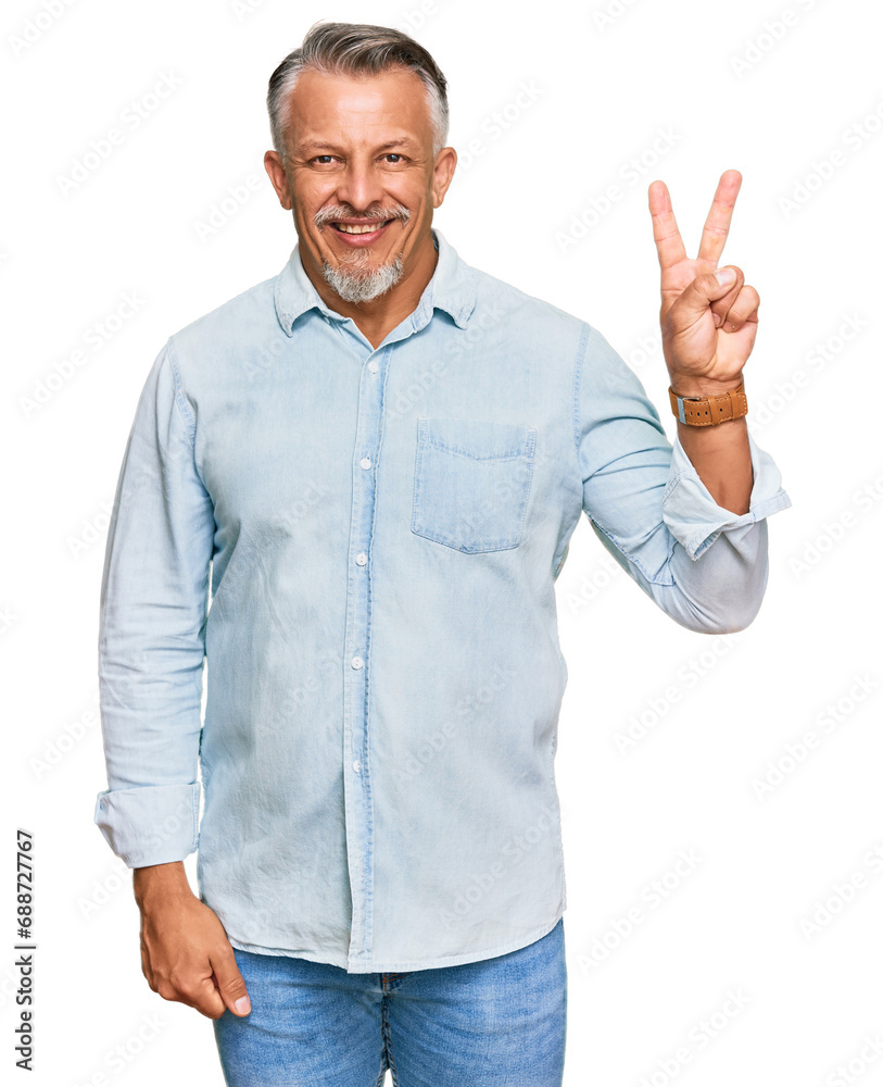 Middle age grey-haired man wearing casual clothes smiling with happy face winking at the camera doing victory sign with fingers. number two.