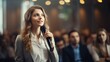 © jp - Jeune femme avec micro en pleine conférence ou séminaire