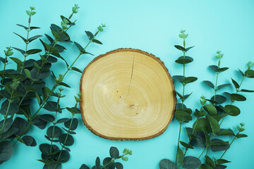 Wall Mural - wooden podium product display stands flat lay with leaves top view on blue background