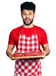 © Krakenimages.com - Young arab man with beard holding board with raw meat celebrating crazy and amazed for success with open eyes screaming excited.