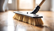 A white wooden broom lies on clean polished floorboards, representing tidiness and the tools needed to maintain an organized space
