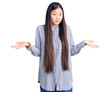 © Krakenimages.com - Young beautiful chinese woman wearing casual shirt clueless and confused expression with arms and hands raised. doubt concept.