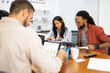 © ADDICTIVE STOCK - Business people examining document in meeting at coworking office