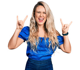 Poster - Young blonde woman wearing casual clothes shouting with crazy expression doing rock symbol with hands up. music star. heavy music concept.