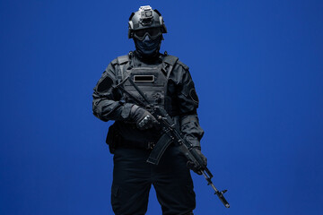 Wall Mural - Soldier in black uniforms with weapon in studio. Concept Military warrior army tactical force to fight crime in city