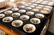 © ADDICTIVE STOCK - Tray with uncooked cupcakes on table
