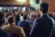 © Fotograf - A man is seen holding a microphone in front of a large crowd. This image can be used to represent public speaking, presentations, concerts, or any event with a large audience