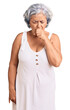 Senior woman with gray hair wearing casual clothes feeling unwell and coughing as symptom for cold or bronchitis. health care concept.