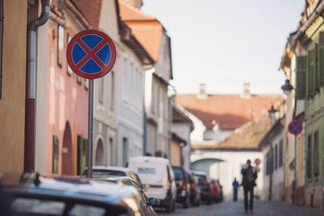 Road signs about evacuation and parking prohibition in old european town, traffic. No parking Sign on the background of buildings on the street in the old city on the sidewalk in perspective.