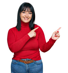 Poster - Young hispanic woman wearing casual clothes smiling and looking at the camera pointing with two hands and fingers to the side.