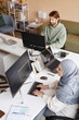 © Seventyfour - High angle portrait of two people working in IT developers office with Muslim young woman as female programmer writing code