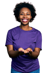 Canvas Print - African american woman with afro hair wearing casual purple t shirt smiling with hands palms together receiving or giving gesture. hold and protection