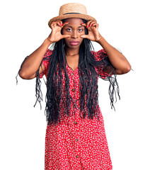 Canvas Print - Young african american woman wearing summer hat trying to open eyes with fingers, sleepy and tired for morning fatigue