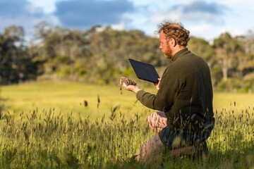 male farmer in agriculture looking at a soil sample, on a farm.