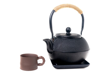 Wall Mural - Traditional cast iron Asian teapot with clay cup on white background