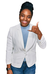 Canvas Print - Young african american woman wearing business clothes smiling doing phone gesture with hand and fingers like talking on the telephone. communicating concepts.