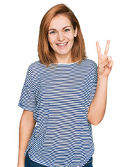 Wall Mural - Young caucasian woman wearing casual clothes showing and pointing up with fingers number two while smiling confident and happy.