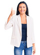 © Krakenimages.com - Young beautiful latin girl wearing business clothes smiling happy and positive, thumb up doing excellent and approval sign