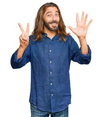 Wall Mural - Attractive man with long hair and beard wearing casual clothes showing and pointing up with fingers number seven while smiling confident and happy.