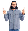 © Krakenimages.com - Young arab man wearing casual clothes smiling confident pointing with fingers to different directions. copy space for advertisement