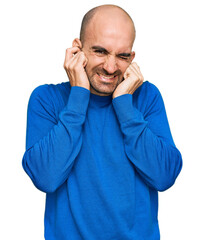 Canvas Print - Young hispanic man wearing casual clothes covering ears with fingers with annoyed expression for the noise of loud music. deaf concept.