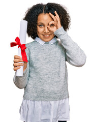 Sticker - Young little girl with afro hair holding graduate degree diploma smiling happy doing ok sign with hand on eye looking through fingers