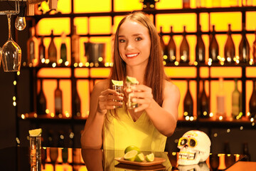 Wall Mural - Young woman with tequila shots in bar at night