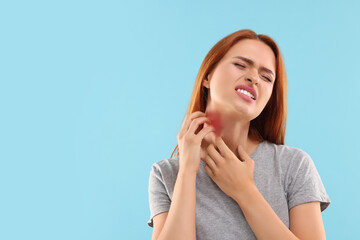 Poster - Suffering from allergy. Young woman scratching her neck on light blue background, space for text