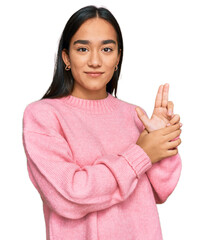 Wall Mural - Young asian woman wearing casual winter sweater holding symbolic gun with hand gesture, playing killing shooting weapons, angry face