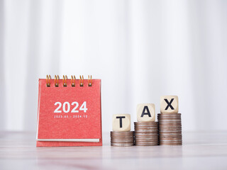 Poster - 2024 desk calendar, Wooden blocks with the word TAX on stack of coins. The concept of saving money for prepare to pay tax in new year 2024