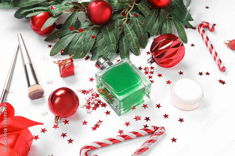 Bottle of perfume with brushes and Christmas decor on white background