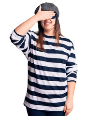 Canvas Print - Young beautiful brunette woman wearing burglar mask smiling and laughing with hand on face covering eyes for surprise. blind concept.