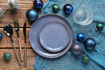 Beautiful table setting for Christmas dinner with decorations on wooden background