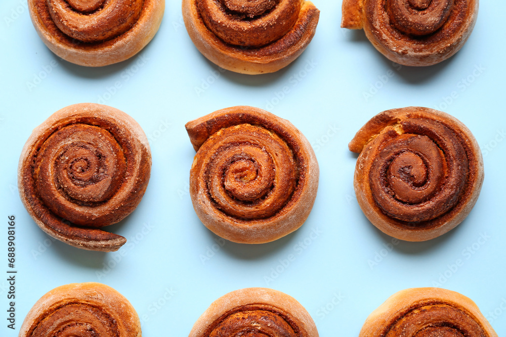 Tasty cinnamon rolls on blue background