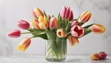 Fototapeta Tulipany - Beautiful bouquet of tulips in glass vase on white marble table. 