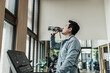 © Charnchai saeheng - A man drinking water on treadmill in gym. Fitness, gym, workout and lifestyle concept.