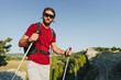 © fotofabrika - Young man hiker travels through the mountains with trekking poles for nordic walking