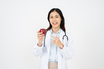 Female doctor with a white coat smiling and holding an apple.