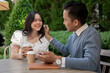 © bongkarn - Young Asian couple listening to music together, having fun together in the green park.