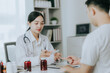 © Witoon - Asian female doctor discussing medicine bottle with male patient in hospital