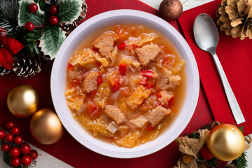 Poster - Menorcan soup with bread, peppers and white cabbage. Christmas food served on a table decorated with christmas motivs.