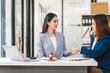 © NanSan - Two middle aged and young Asian lawyer in a formal suit consoles a client during a legal consultation, with a gavel and documents on the table.