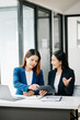 © Nuttapong punna - Two Asian businesswoman discuss investment project working and planning strategy with tablet laptop computer
