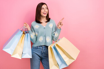 Wall Mural - Photo of pretty shiny lady wear turquoise clothes holding shoppers looking pointing empty space isolated pink color background