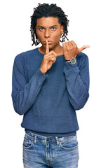 Wall Mural - Young african american man wearing casual winter sweater asking to be quiet with finger on lips pointing with hand to the side. silence and secret concept.