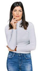 Wall Mural - Beautiful brunette woman wearing casual clothes with hand on chin thinking about question, pensive expression. smiling with thoughtful face. doubt concept.