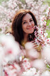 © dmitriisimakov - beautiful woman brunette in flowering trees spring nature travel walk