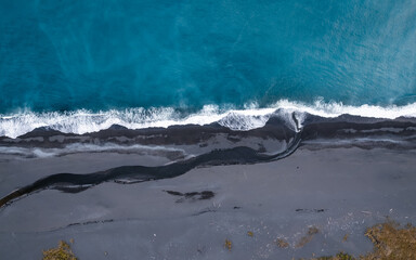 Wall Mural - aeriel view of ocean waves on black sand beach