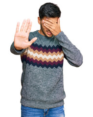 Wall Mural - Young handsome man wearing casual winter sweater covering eyes with hands and doing stop gesture with sad and fear expression. embarrassed and negative concept.